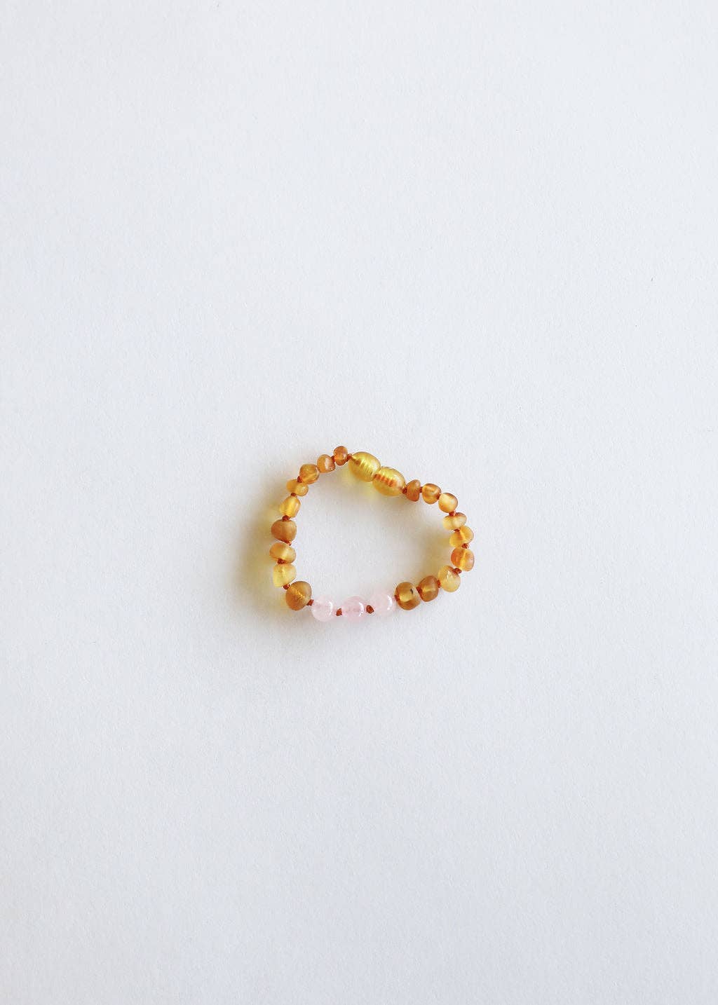 A raw honey amber and rose quartz baby bracelet.