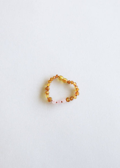 A raw honey amber and rose quartz baby bracelet.