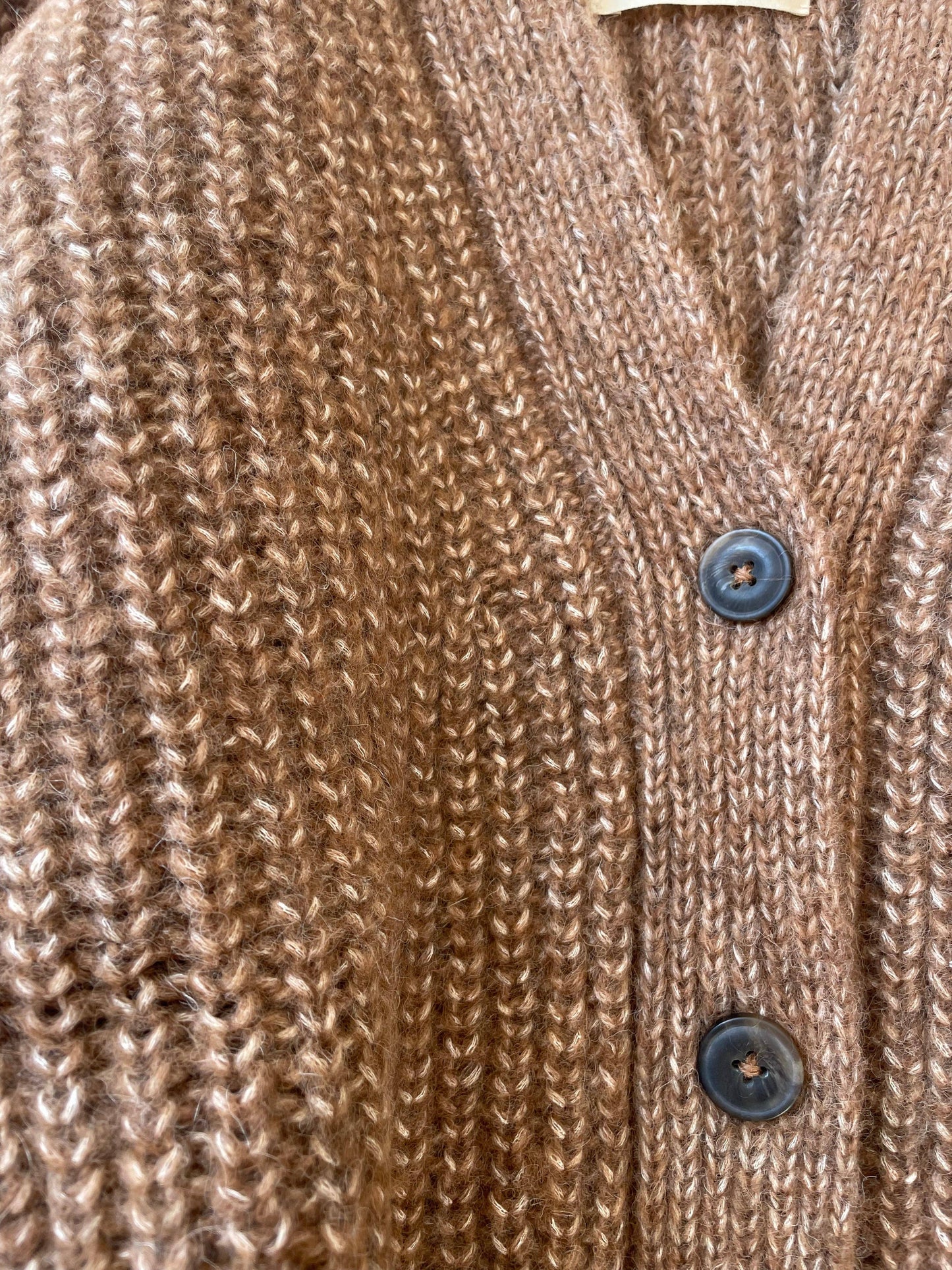 Close-up of a brown alpaca wool knitted cardigan with dark brown buttons.
