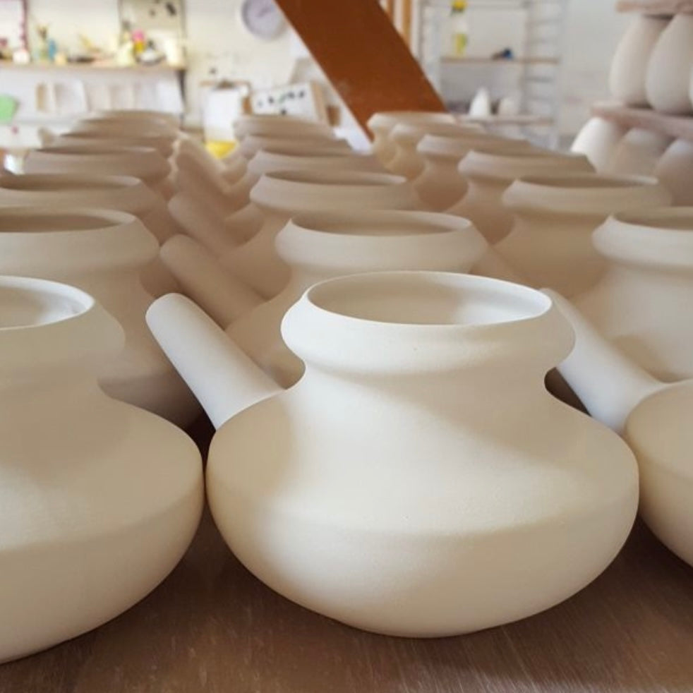 Row of white ceramic neti pots.