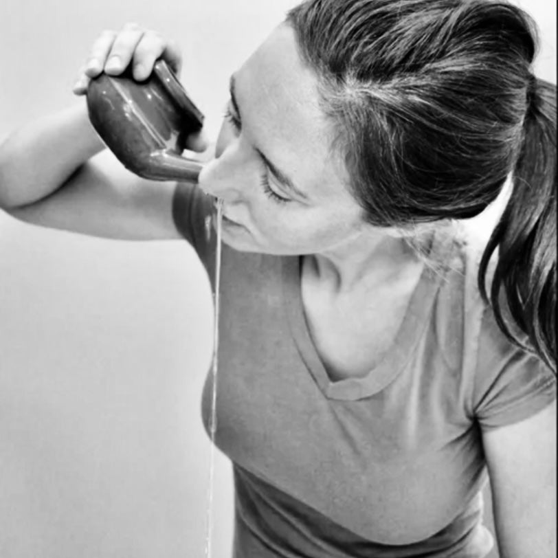 Women using a ceramic neti pot.