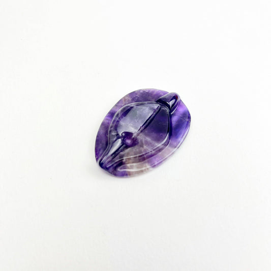 A amethyst vulva worry stone.