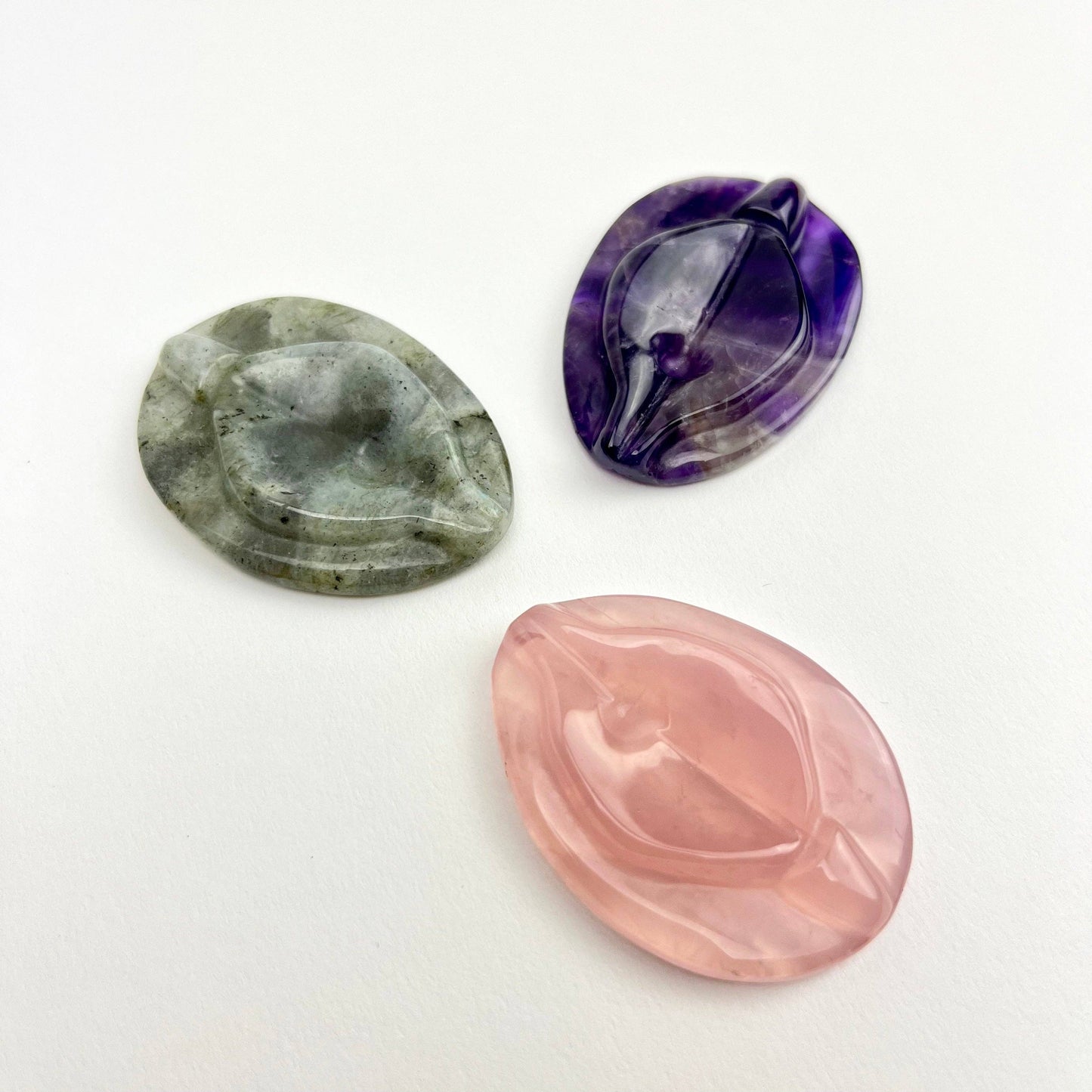 Pocket size vulva shaped rose quartz worry stone.