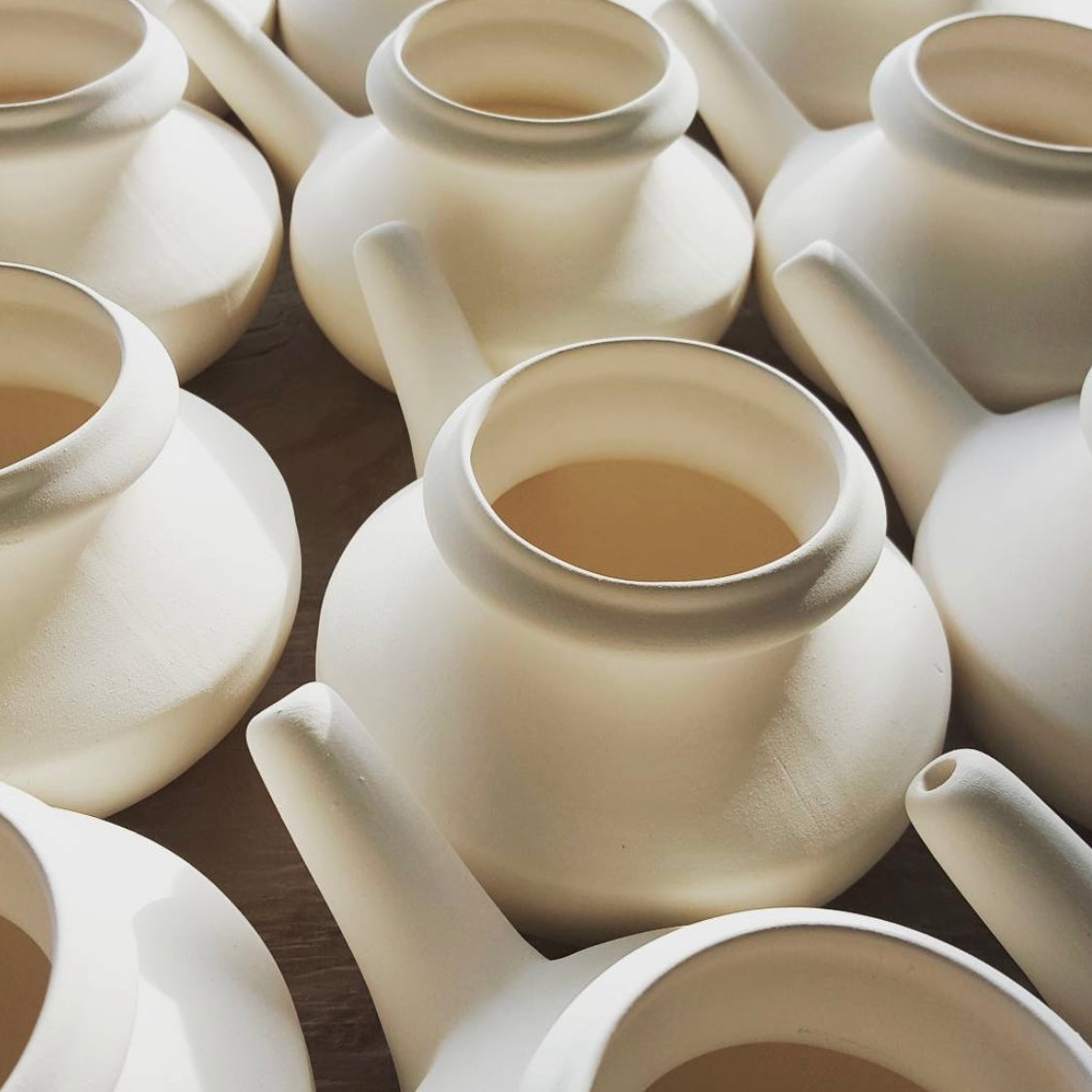 White ceramic neti pots.