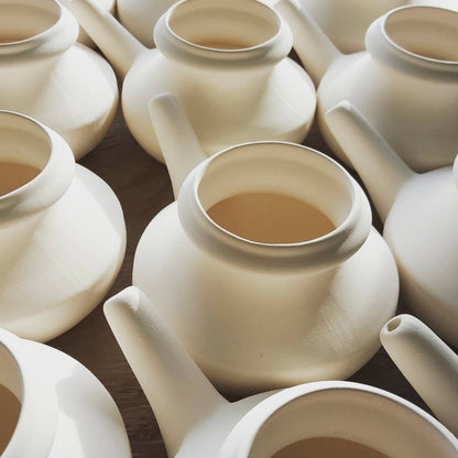White ceramic neti pots.