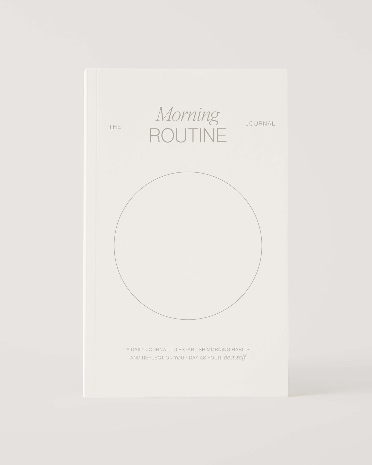 White book titled 'The Morning Routine Journal' on a light gray background