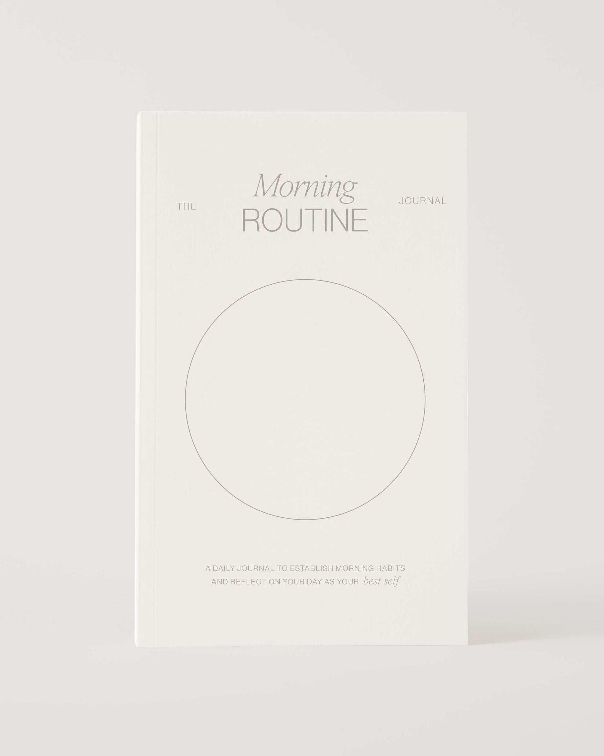 White book titled 'The Morning Routine Journal' on a light gray background