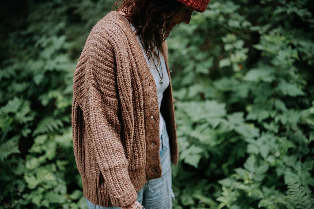 Woman wearing a brown knitted alpaca cardigan.